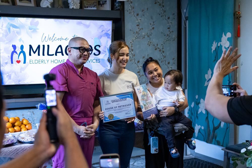 House of Retrievers receiving a certificate of appreciation under the Milagros welcome screen